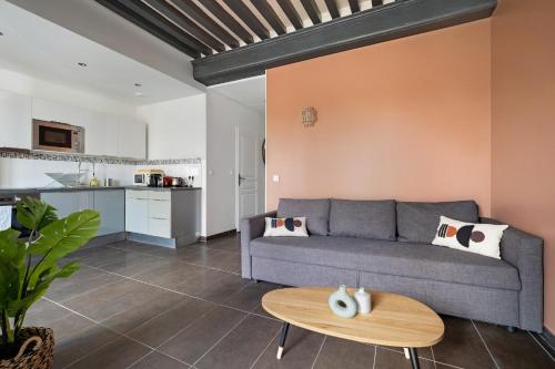 ein Wohnzimmer mit einem Sofa und einem Tisch in der Unterkunft Lyon Cité- Appartement vue Rhône terrasse-Caluire in Caluire-et-Cuire