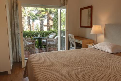 1 dormitorio con 1 cama y balcón con mesa y sillas en Premium Apartments Punta Kolova, en Opatija