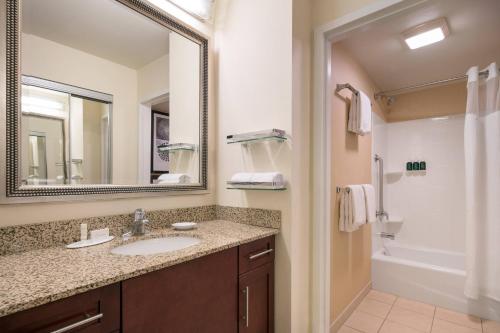 a bathroom with a sink and a mirror and a tub at Residence Inn by Marriott Camarillo in Camarillo