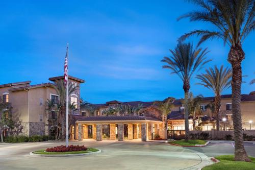 a large building with palm trees in front of it at Residence Inn by Marriott Camarillo in Camarillo