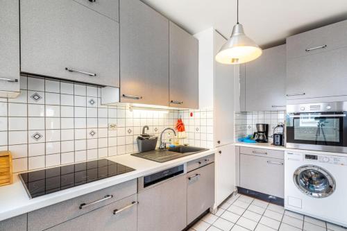 une cuisine blanche avec un évier et un lave-vaisselle dans l'établissement Catch a break near the Seine, à Charenton-le-Pont