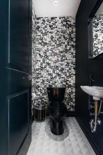 a bathroom with a black toilet and a sink at Placemakr Wall Street in New York