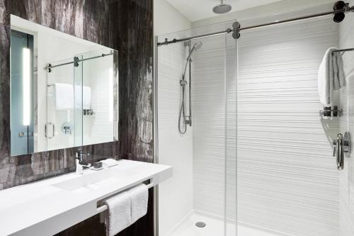 W łazience znajduje się umywalka i przeszklony prysznic. w obiekcie AC Hotel Tucson Downtown w mieście Tucson