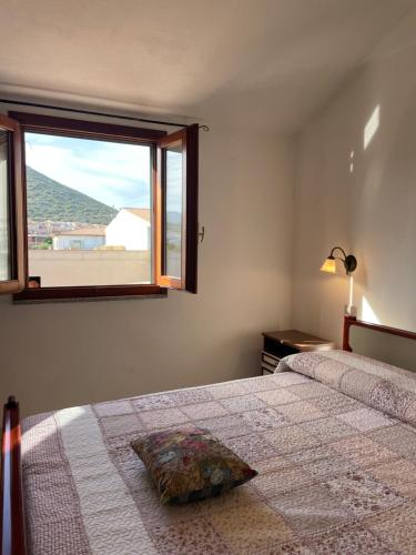 um quarto com uma cama e uma janela com vista em La casa di Tonia em La Caletta