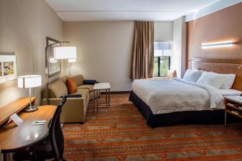um quarto de hotel com uma cama e um sofá em SpringHill Suites by Marriott Deadwood em Deadwood