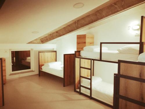 Zimmer mit 3 Etagenbetten und einem Spiegel in der Unterkunft GARAGE HOSTEL in Nova Gorica