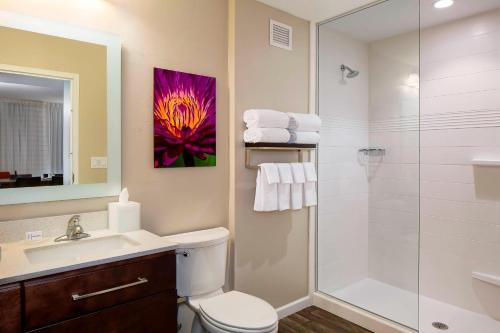 a bathroom with a shower and a toilet and a sink at TownePlace Suites by Marriott Fort Myers Estero in Estero