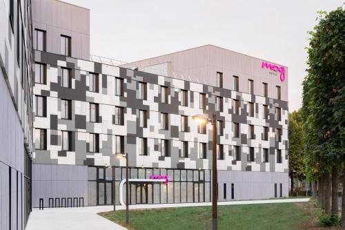 a building with a pink sign on the side of it at Moxy Paris Val d'Europe in Montévrain