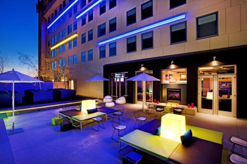 a patio with tables and chairs and a building at Aloft Tucson University in Tucson