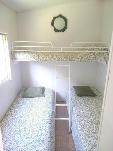 1 dormitorio con 2 literas y escalera en Bungalow, en Sainte-Marie-du-Mont