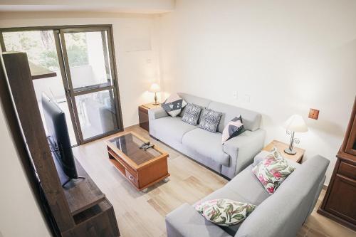 a living room with a couch and a tv at Recreio Paradisíaco in Rio de Janeiro