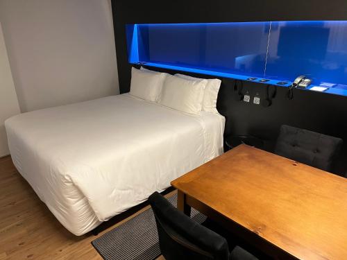 a bedroom with a bed and a table with a desk at Park Plaza Moinhos Porto Alegre in Porto Alegre