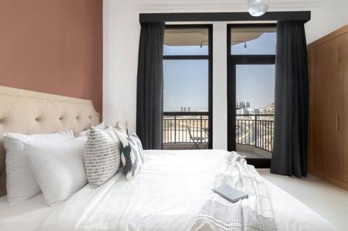 a bedroom with a white bed with a window at Chez Eric in Dubai