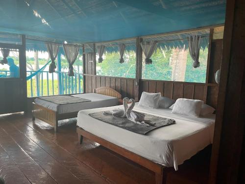 a bedroom with two beds with a swan on it at Yaku Amazon Lodge & Expeditions in Paraíso