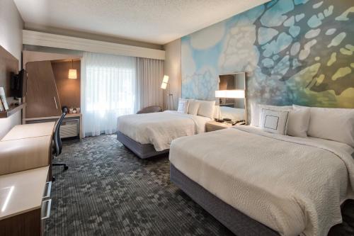 a hotel room with two beds and a painting on the wall at Courtyard by Marriott Rock Hill in Rock Hill