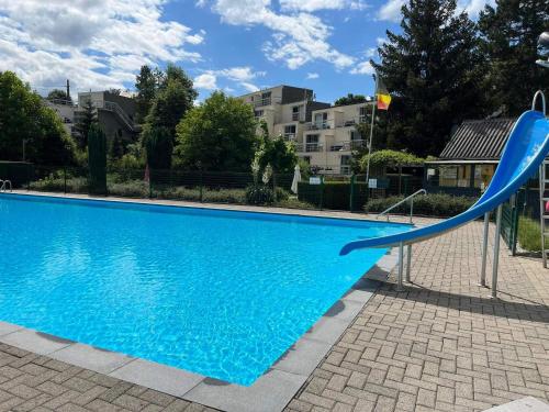 un toboggan bleu à côté d'une piscine dans l'établissement studio 21, à Rochefort