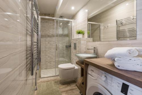 a bathroom with a shower and a washing machine at Apartment San Antonio in Rovinj