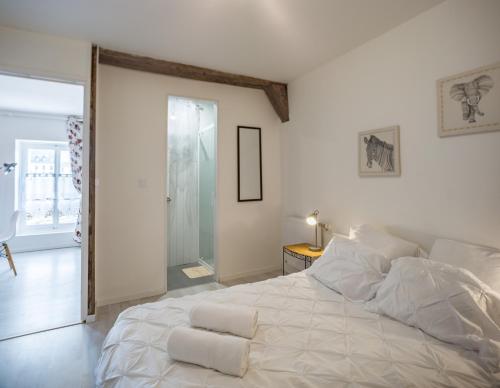 1 dormitorio blanco con 1 cama blanca grande con almohadas en Duplex Saussier- Centre historique - idéal Groupe, en Troyes