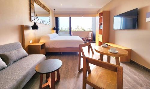a hotel room with a bed and a couch at Sofía Boutique Condos by Bunik in Playa del Carmen