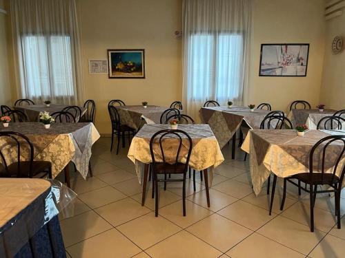 una sala da pranzo con tavoli e sedie con cercatore di Hotel Vienna a Rimini