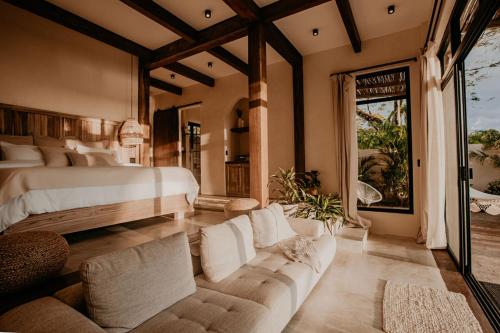 a bedroom with a bed and a couch in it at Sansara Surf Yoga & Resort in Cambutal