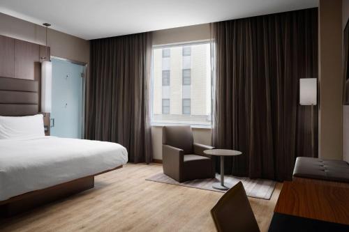 una camera d'albergo con letto, scrivania e sedia di AC Hotel by Marriott Dallas Downtown a Dallas