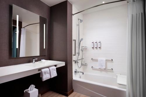a bathroom with a tub and a sink and a shower at AC Hotel by Marriott Dallas Downtown in Dallas