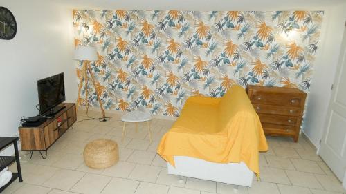 - un salon avec une couverture jaune sur un mur dans l'établissement Studio la Traverse du Colombier, à Rians