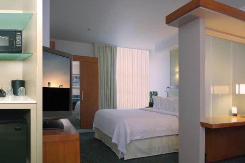 a hotel room with a bed and a flat screen tv at SpringHill Suites by Marriott Las Vegas North Speedway in Las Vegas