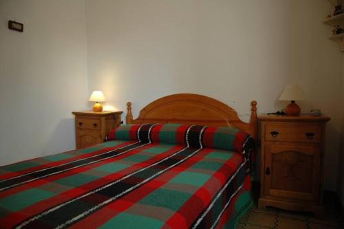 1 dormitorio con 1 cama con una manta a rayas de colores en Casa del Priorat "Ca La María", en Marçà