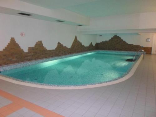 a large swimming pool in a room with a tile floor at Apartament Brandy Radowid in Zakopane