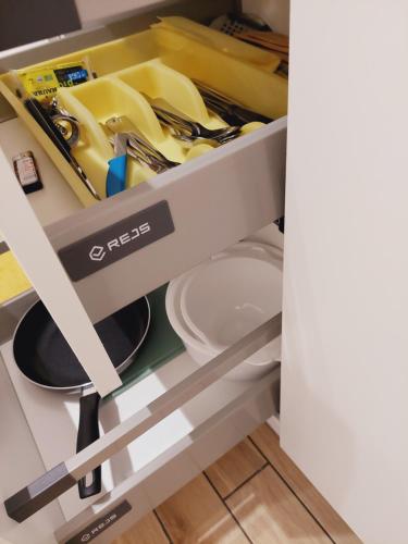 a shelf in a kitchen filled with dishes and utensils at Apartament Finezja in Sandomierz