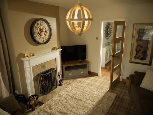 a living room with a fireplace and a clock on the wall at Brookwood in Pickering