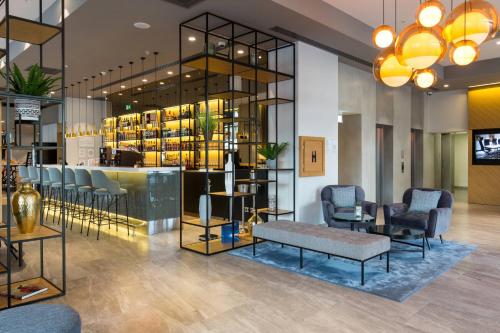 a lobby with chairs and a bar in a store at Courtyard by Marriott Banja Luka in Banja Luka