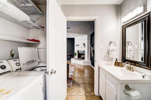 a kitchen with white cabinets and a sink and a mirror at Country Village Condo in Humble