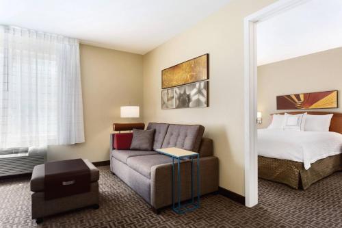 TownePlace Suites Salt Lake City Layton في لايتون: غرفة في الفندق مع أريكة وسرير