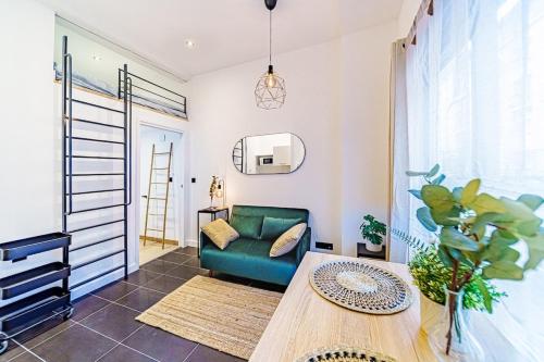 uma sala de estar com um sofá verde e uma mesa em Lyon Cité-Studio Bellevue Caluire em Caluire-et-Cuire