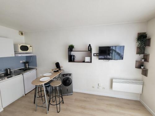 uma cozinha com uma mesa e bancos num quarto em Les appartements de Saint Charles em Marselha