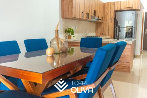 a kitchen with a dining table and blue chairs at Torre Oliva in Mazatlán