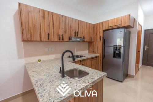 a kitchen with a sink and a refrigerator at Torre Oliva in Mazatlán