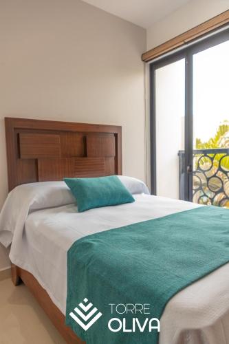 a bed in a bedroom with a large window at Torre Oliva in Mazatlán
