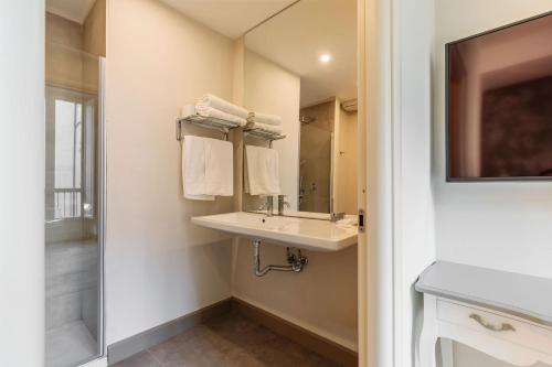 a bathroom with a sink and a mirror and a shower at XX SETTEMBRE Urban Relais in Turin