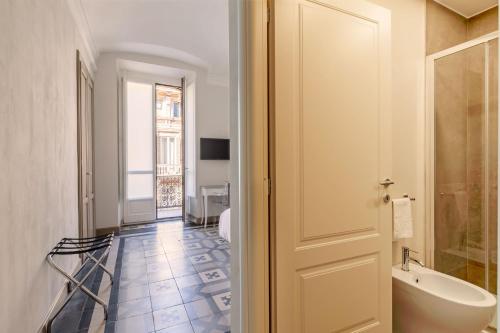 un bagno con vasca, lavandino e porta di XX SETTEMBRE Urban Relais a Torino