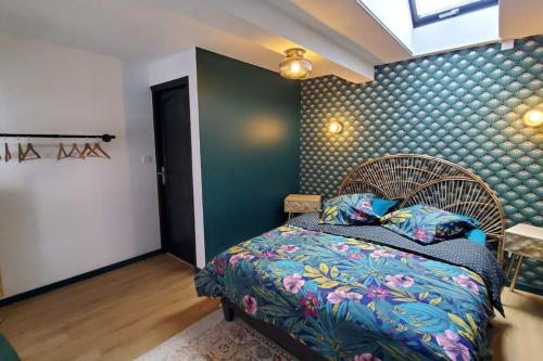 1 dormitorio con cama y pared azul en La P'tite Arrageoise, en Arras