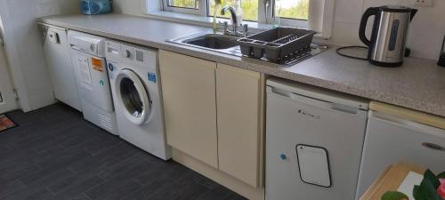 a kitchen with a sink and a washing machine at Newmarket in Stornoway