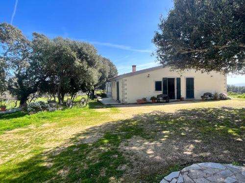 a white house with trees and a yard at La Striscia Larga in San Pasquale