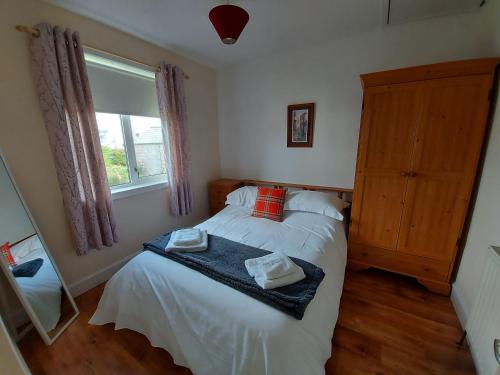 a bedroom with a bed with two towels on it at Newmarket in Stornoway
