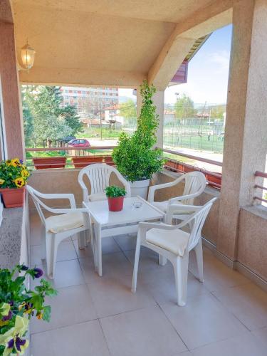 a white table and chairs on a balcony with plants at My Parents Guest House in Petrovec