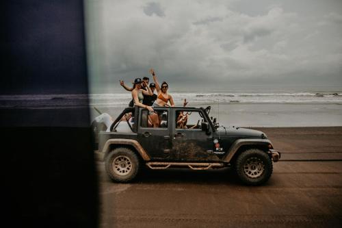 a group of people riding in a jeep on the beach at Sansara Surf Yoga & Resort in Cambutal