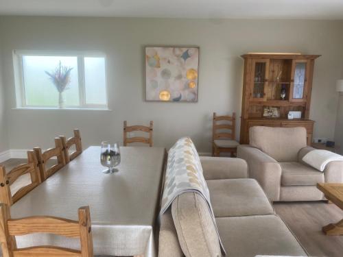 a living room with a dining room table and chairs at Ard Alainn Lodge, Adorable Setting, scenic views in Grange